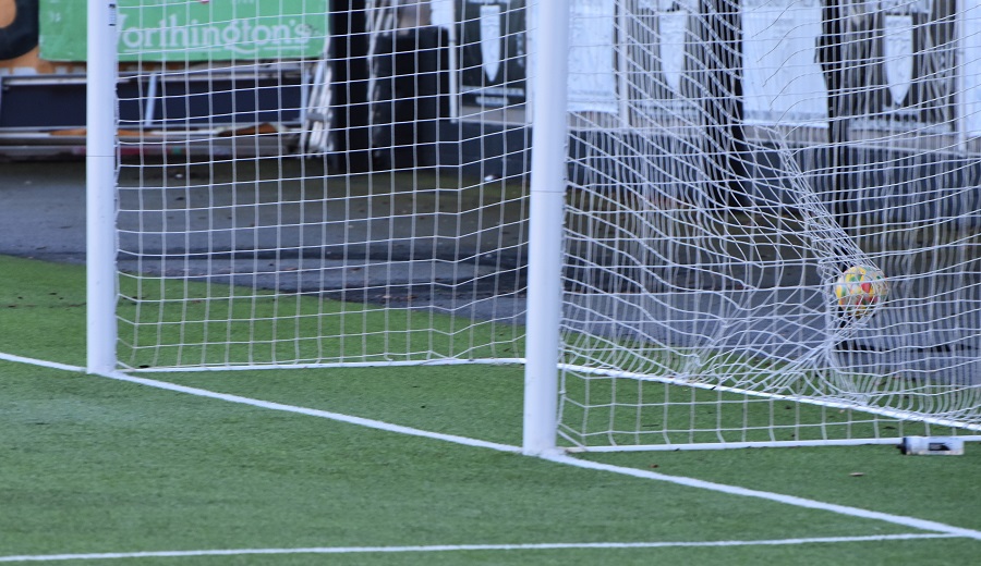Merthyr’s Jemmett-Hutson side foots the ball into the empty net after winning the challenge with Armstrong