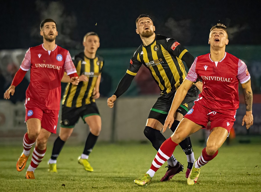 Will Tunnicliff concentrates on getting to the ball before Tony-James Lee