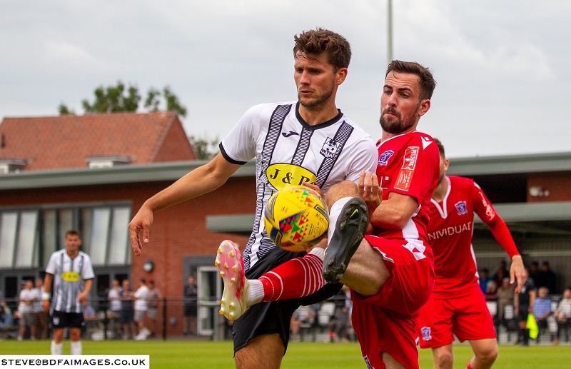 Lewis Hall challenges the Wimborne forward