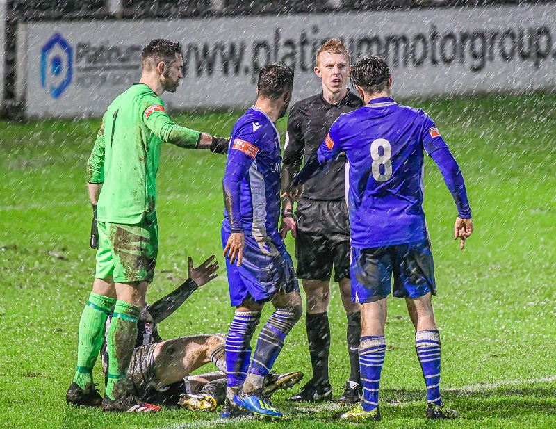 The Marine players question the ref’s decision during the rain storm