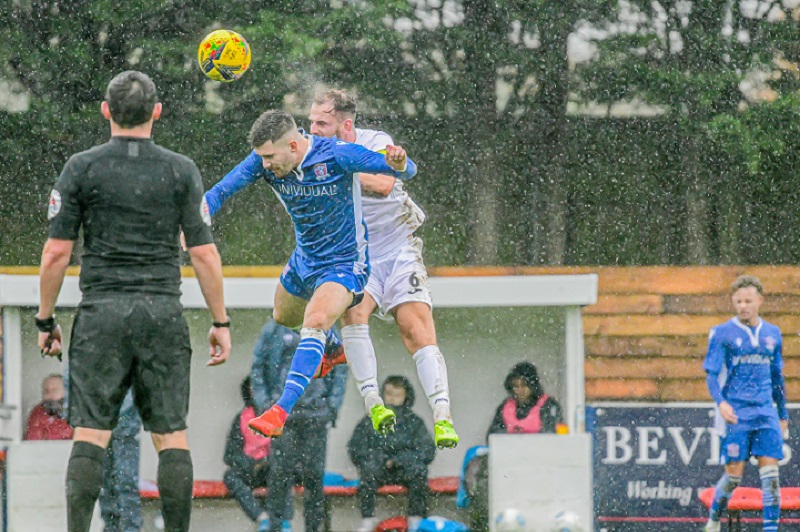 The heavens open as Zack challenges for the ball